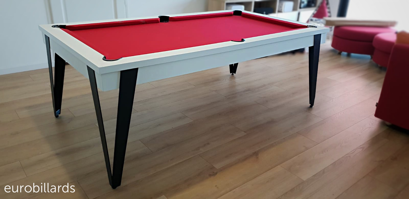 billard industriel au design contemporain, modèle PURE de la marque Eurobillards. La finition nano blanc est portée par quatre pieds en métal noir faisnt le lien avec les poches noires qui ornent le tapis de jeu rouge.